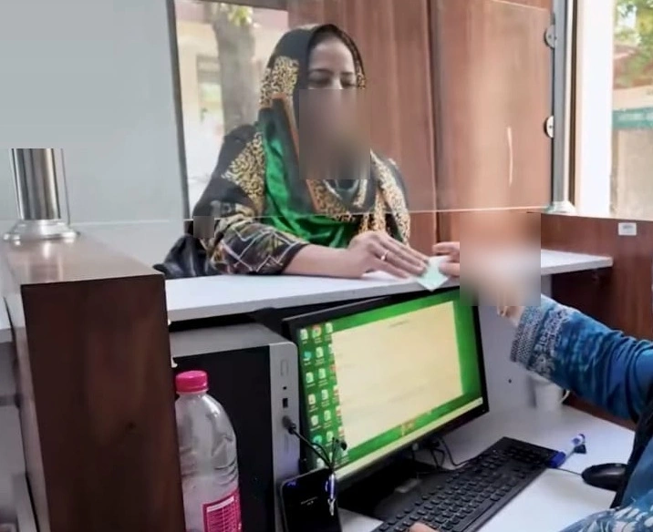 Woman giving CNIC for BISP payment status check at registration center in Pakistan